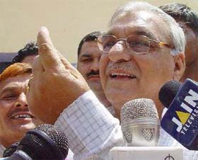 Haryana Chief Minister Bhupinder Singh Hooda shows the ink mark on his finger after casting his vote at Sanghi village on Thursday