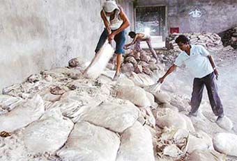 Labourers hired by the MP Government remove sacks filled with chemical toxic waste from a building