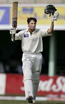 Pakistan batsman Younis Khan raises his bat and helmet after scoring a century on the opening day of the second and final Test match against the West Indies at Sabina Park in Kingston on Friday.