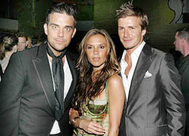 Singer Robbie Williams, Victoria Beckham and her husband/soccer player David Beckham pose at The David Beckham Academy launch party