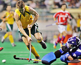 Australias Michael McCann is tackled by South Koreas goalkeeper Dong Sik-ko during the final of the 14th Sultan Azlan Shah Cup in Kuala Lumpur on Sunday