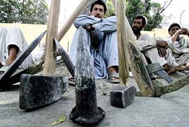 Pakistani labourers wait on the roadside in the hope of work in Islamabad on Monday. Pakistan plans to increase defence spending in the new Budget being unveiled on Monday. Pakistans gross domestic product (GDP) grew at a rate of 8.3 per cent against a target of 6.6 per cent this year. 