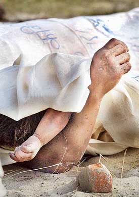 The hands of a woman and a child are seen as the bodies of victims of a landmine explosion are covered in Chitwan district, 150 km south of Kathmandu, on Monday.