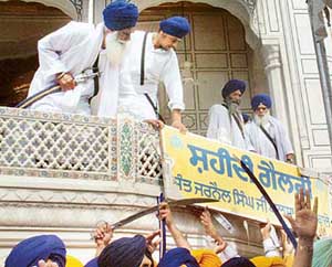 Activists of radical Sikh outfits hang a board of Shaheed Gallery in front of Akal Takht on Monday in Amritsar. 