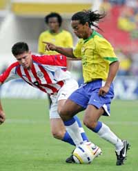 Brazilian forward Ronaldinho battles for the ball with Paraguays Cesar Ramirez 