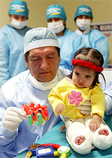 Dr Luis Rubio holds 13-month-old Milagros Cerron of Peru as she plays with toys at a hospital in Lima on Monday