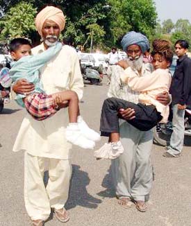 The father (right) and an uncle of two of the injured children of Chehlan village near Amloh town carry them to district courts Ludhiana. The feet of the children have been badly burnt when they accidentally stepped on effluents dumped in a playground. 
