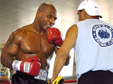 Former heavyweight champion Mike Tyson spars with trainer Jeff Fenech during a public workout at Howard University in Washington on Tuesday