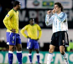 Argentinas Hernan Crespo celebrates after scoring his teams third goal as Brazils Adriano looks on during their World Cup qualifying match in Buenos Aires 