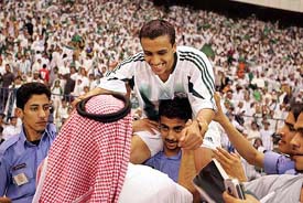 Saudi Arabias Mohammed Alshalboub is carried by supporters after winning their soccer match against Uzbekistan
