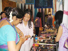 Chinese women try out Indian bangles at the Indian Pavilion during the 13th China Kunming Import and Export Commodities Fair on Friday. 