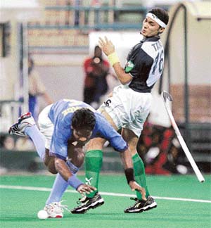 Indias Ignace Tirkey misses his step as Pakistans Tariq Aziz looks on during the Azlan Shah Cup