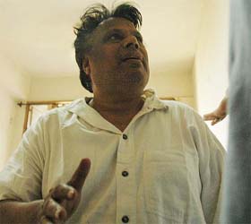 Detainee under COFEPOSA Adishwar Jain tries to prevent Tribune photographer Sayeed Ahmed from taking his picture in the Civil Hospital, Ludhiana