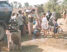 Women and children draw drinking water from a tanker in a suburb of Jammu that is facing an acute water shortage.