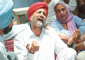 Grieving family members of Lajja Ram, who died after falling from the roof of his house while chasing away monkeys