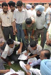 Candidates who appeared in the CET conducted by Punjab Technical University, along with their parents, prepare their representation demanding re-evaluation of their results on the university campus in Jalandhar on Monday. 