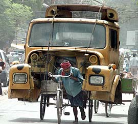A man pushes a rickshaw-trolley laden with a trucks scrap on his way to the junk market in Allahabad on Tuesday. 