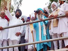 Devotees, including former PCC president Santokh Singh Randhawa and Mr Sukhjinder Singh Randhawa, Parliamentary Secretary for Agriculture, Punjab, view the Kartarpur Sahib gurdwara from the Indo-Pakistan border.