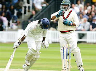 Kumara Sangakkara of MCC returns safely to the crease as Rahul Dravid of International XI hits the stumps during a tsunami relief match at Lords in London on Tuesday