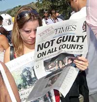 A Michael Jackson fan reads a special edition of the Santa Maria Times newspaper after Jackson's not-guilty verdict at Neverland Ranch in Los Olivos, California, on Tuesday.