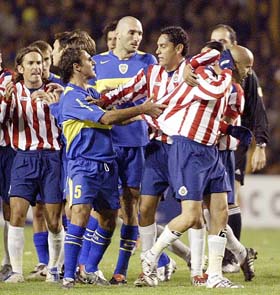 Adolfo Bautista of Guadalajara is protected by team-mates after being ejected by the referee as players of Boca Juniors try to confront him during a Libertadores Cup soccer match in Buenos Aires on Tuesday