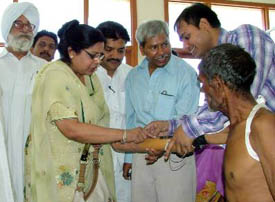 Mrs Sushma Singla, wife of Punjab Finance Minister Surinder Singla, helps out a doctor in fitting an artificial arm to a physically challenged person in Bathinda on Thursday
