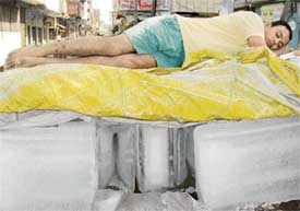 A vendor sleeps over blocks of ice to keep the heat at bay in Ambala on Sunday.