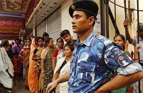 A rapid action force personnel keeps vigil at a booth in Kolkata during the civic elections