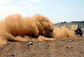 A jeep leaves a trail of dust as it participates in the Mud Challenged Car Rally 2005 in Bhopal