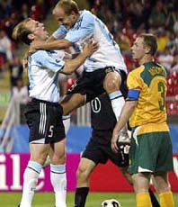 Argentinas Luciano Figueroa celebrates with team-mate Esteban Cambiasso after scoring a goal while Australias Craig Moore looks on during their Confederations Cup soccer match in Nuremberg, Germany