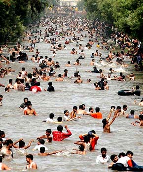 People cool off at a canal in Lahore, Pakistan, on Sunday
