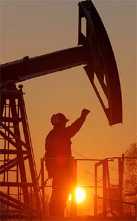 A worker stands under a derrick at a Yuganskneftegaz oil processing facility, the core unit of oil company Yukos