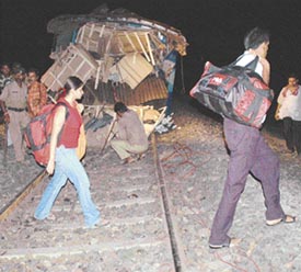 Passengers leave with their luggage after the New Delhi-Puri Puroshottam Express in which they were travelling collided with a light engine near the Gamariah station in Jamshedpur on Monday night. 