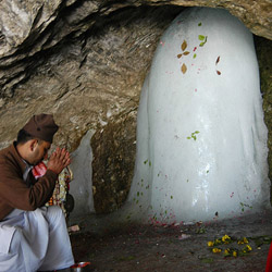 A Hindu devotee prays before the Shiva Lingum