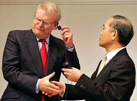 Newly appointed Sony Corp., Chairman and CEO Howard Stringer (left), gets help removing a tangled earphone from Ryoji Chubachi, the new President and head of electronics, before a press conference in Tokyo on Thursday. 