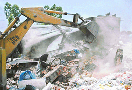 A JCB razes an illegal structure at Kajheri village in Chandigarh on Thursday. 