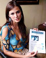 Peruvian Miss World Maria Julia Mantilla shows a copy of her photographs, published in El Mundo, a Spainsh newspaper t during an interview in Lima, Peru, on Wednesday