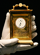 A curator holds a pocket watch that belonged to Lord Nelson