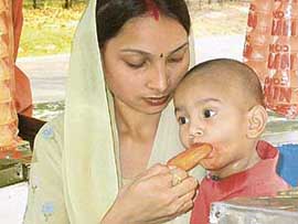A taste of affection: A mother offers an ice-cream lolly to her little one for beating the heat in Chandigarh 