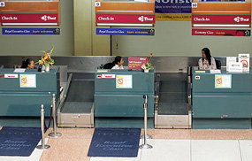 Check-in officers wait for passengers at Phuket International Airport on Saturday. Blaming a steep decline in passenger numbers, Hong Kong airline Dragonair will shut its Phuket office in Thailand from July 1. At least 14 of the 20 airlines that flew to Phuket before the December 26 tsunami have since stopped flying there.