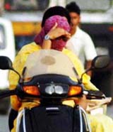 The young girl realises that her scarf is not good enough to ward off the blistering heat on a sultry Saturday afternoon in Ludhiana