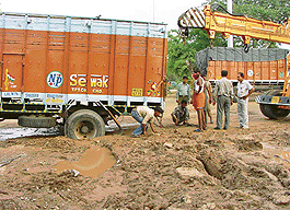 A truck is stuck in a pothole caused by heavy showers in Sector 28, Chandigarh, on Sunday.