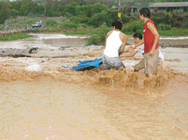 Residents of Kishangarh trying to retrieve their belongings on the submerged road that links the village with Chandigarh on Sunday morning.