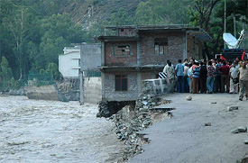Portion of houses washed away by the torrents at Nogli village, near Rampur, on Monday. 