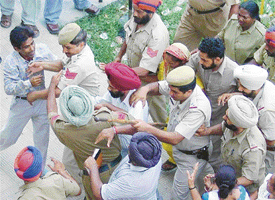 Policemen try to stop an unidentified youth who was about to manhandle advocate Thakur Singh who has been arrested for murder of his munshi