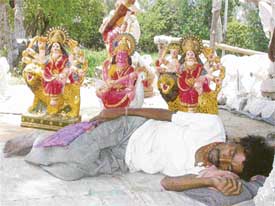  A statue seller steals a few winks on a humid day in Chandigarh