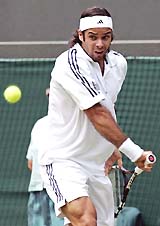 Fernando Gonzalez of Chile plays a shot during his quarterfinal match against Roger Federer of Switzerland at Wimbledon on Wednesday