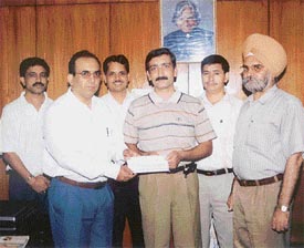 Mr D.K. Bhagat, Senior Divisional Manager, LIC, Ludhiana, hands over a cash prize to Kirti Sharma who secured the third spot in the north zone chess meet of LIC of India 