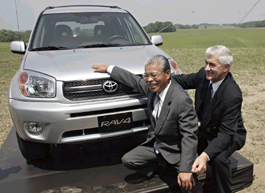 Toyota Motor Corps Managing Director Atsushi Niimi (left) and President of Toyota Motor Manufacturing (North America) Ray Tanguay pose in front of a Rav 4 model on Thursday by a field where a new plant to produce the vehicle will be built in Woodstock, Ontario. The plant will employ nearly 1,300 workers.