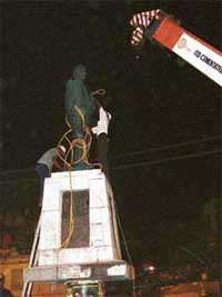 Workers try to remove the statue of Shaheed Kartar Singh Sarabha with the help of a JCB machine 